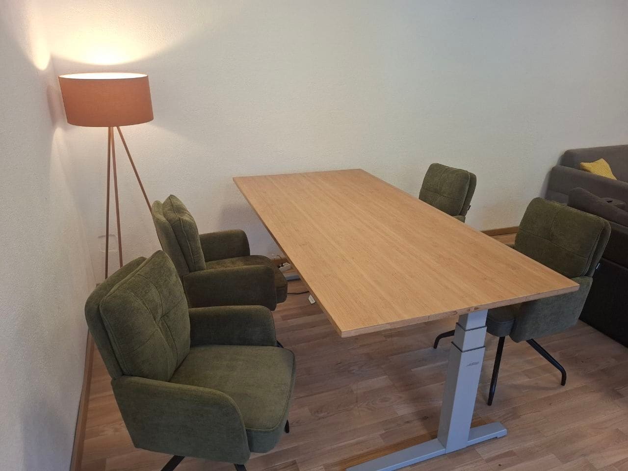 Esstisch aus hellem Holz mit vier Sesseln und Stehlampe