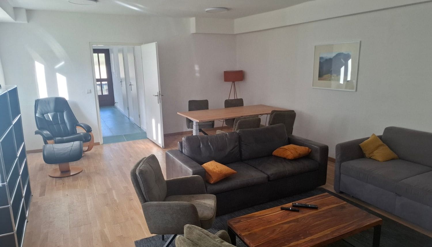 Offener Wohn- und Essbereich des Lofts in Gunzesried mit Ledersofa, Sesseln und Esstisch