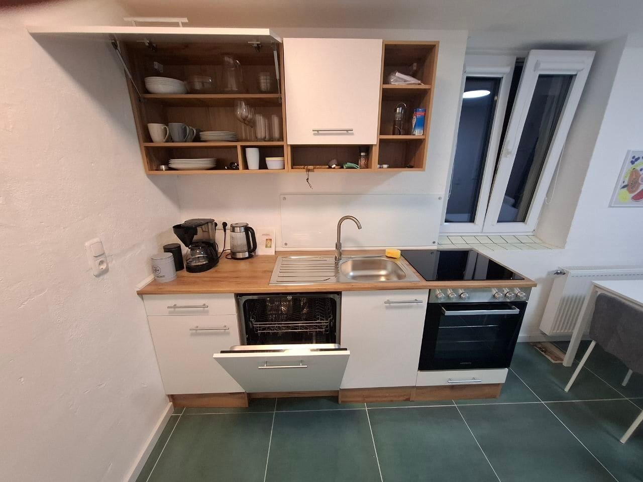Küche mit Geschirrspüler, Backofen, Kochfeld und Spüle