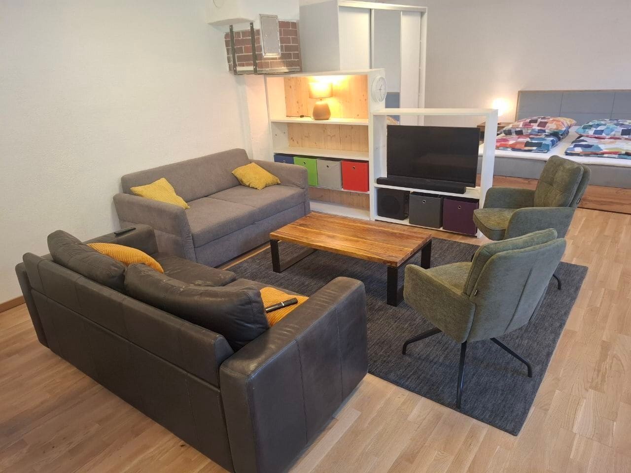 Wohnbereich mit grauer Couch, Sitzsäcken und Fernseher